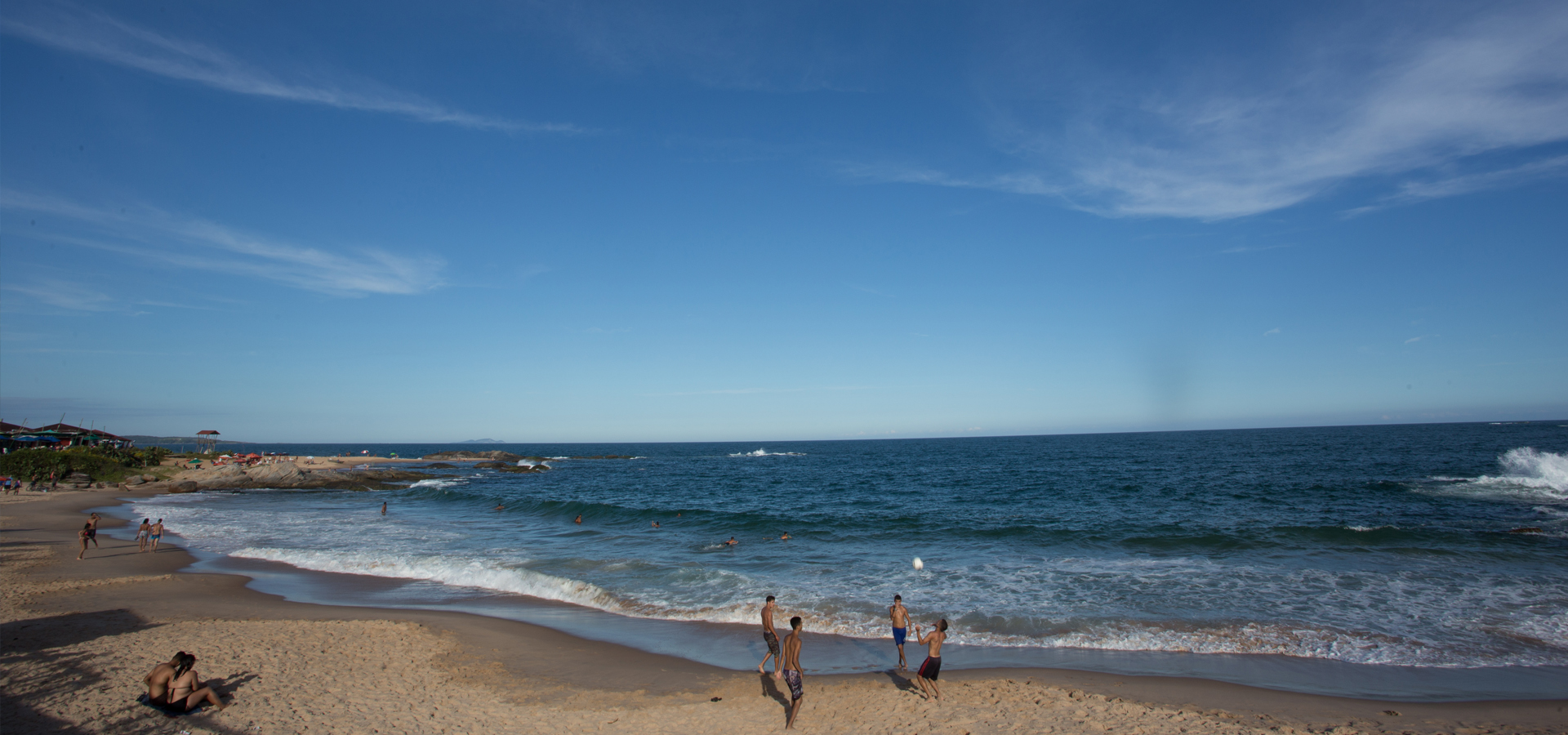 Foto de uma família curtindo a Praia Boca da Barra num dia ensolarado