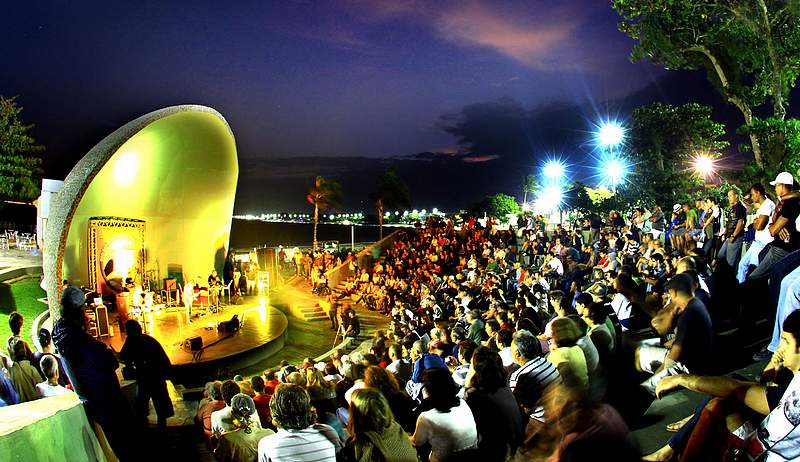 Concha acústica com a apresentação musical e pessoas na arquibancada