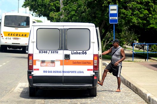 Foto de um passageiro subindo numa Van do transporte público