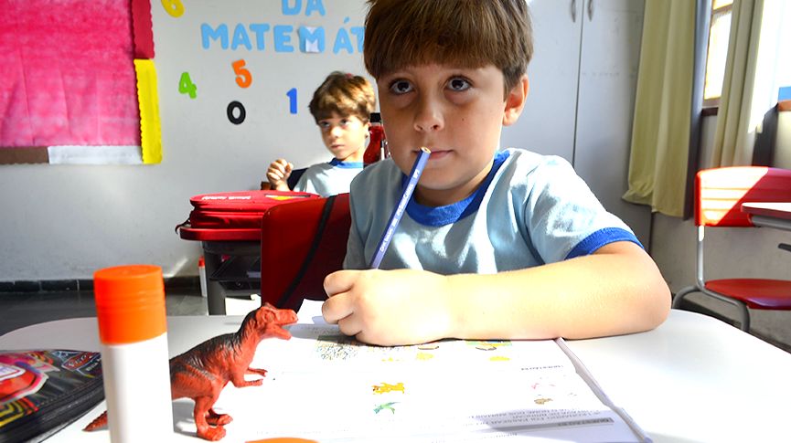 Foto de aluno olhando para frente durante atividade em sala de aula