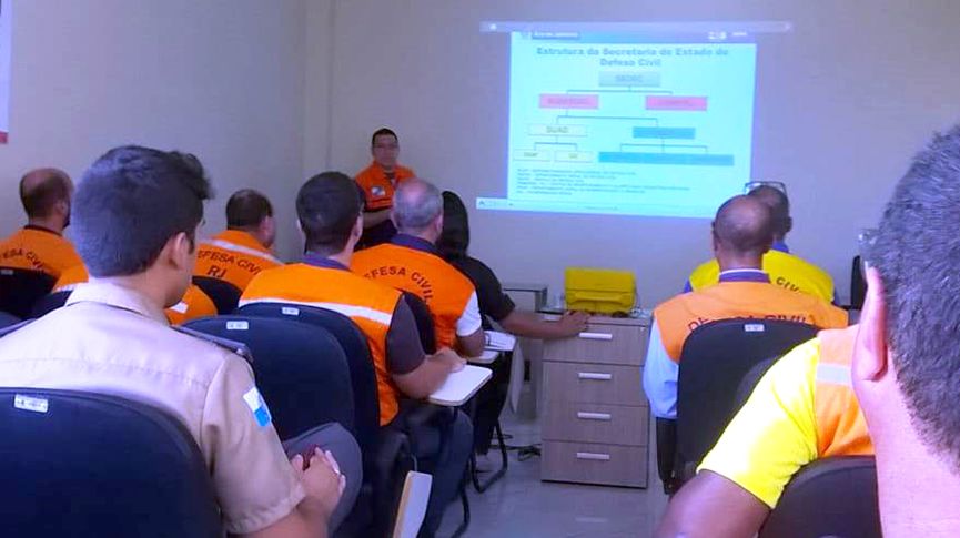 Foto de vários gentes da Defesa Civil assistindo uma palestra