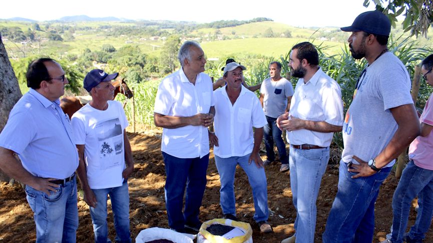Foto do prefeito Carlos Augusto conversando com agricultores ao lado de autoridades e servidores da prefeitura