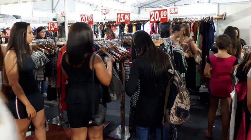 Foto de consumidores observando as ofertas em estandes
