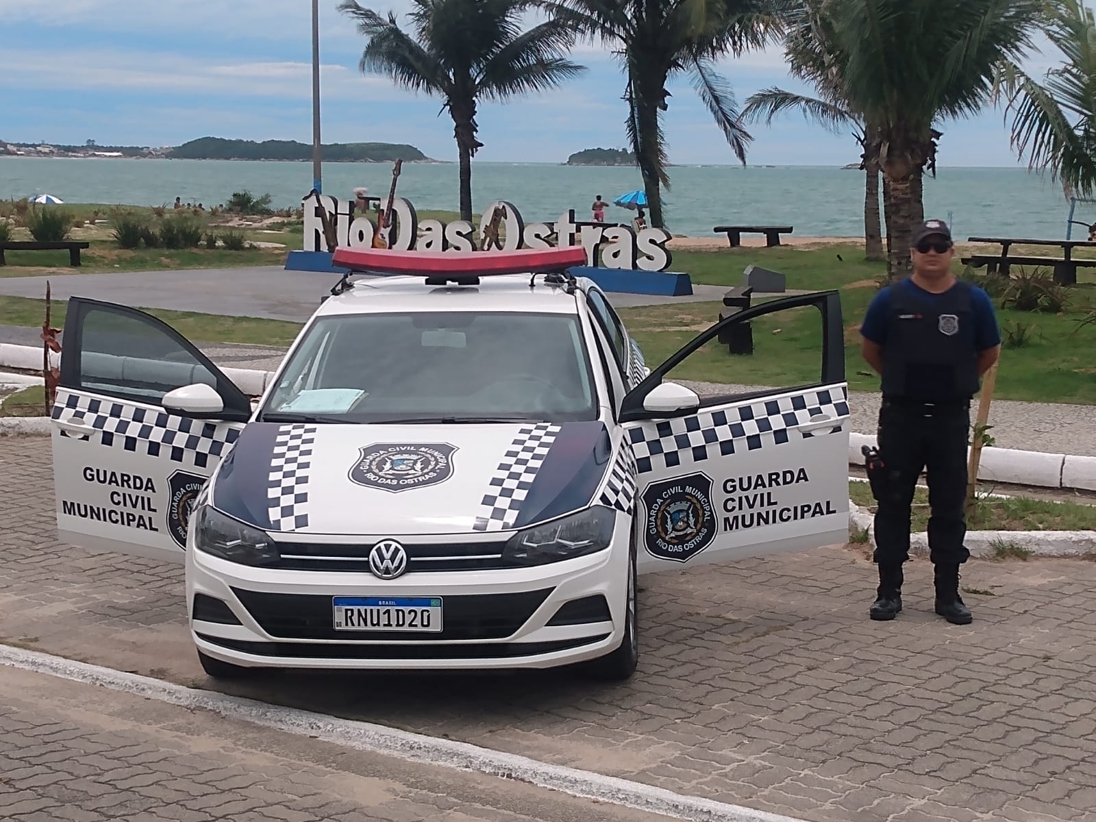 viatura com portas abertas e guarda civil ao lado em ponto turístico