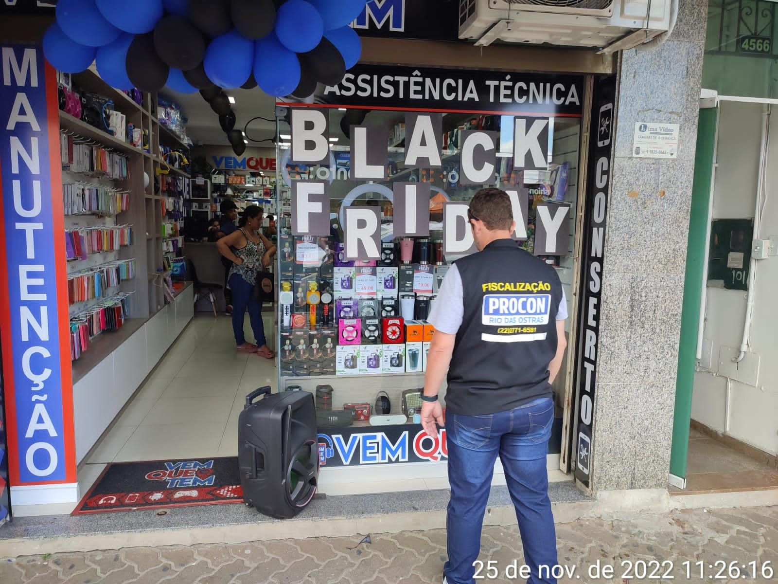 Fiscal do Procon em frente à vitrine com anúncio de Black Friday