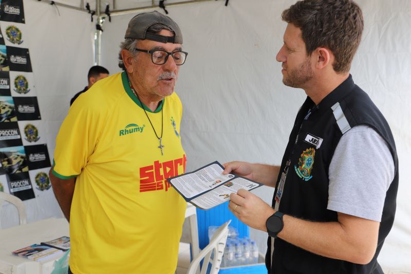 Fiscal do Procon entrega panfleto e entrega para senhor