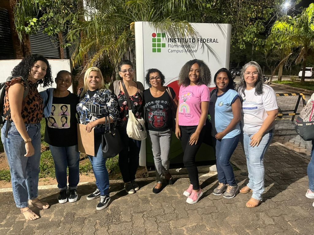 Alunas perfiladas em frente à placa de indentificação do IFF