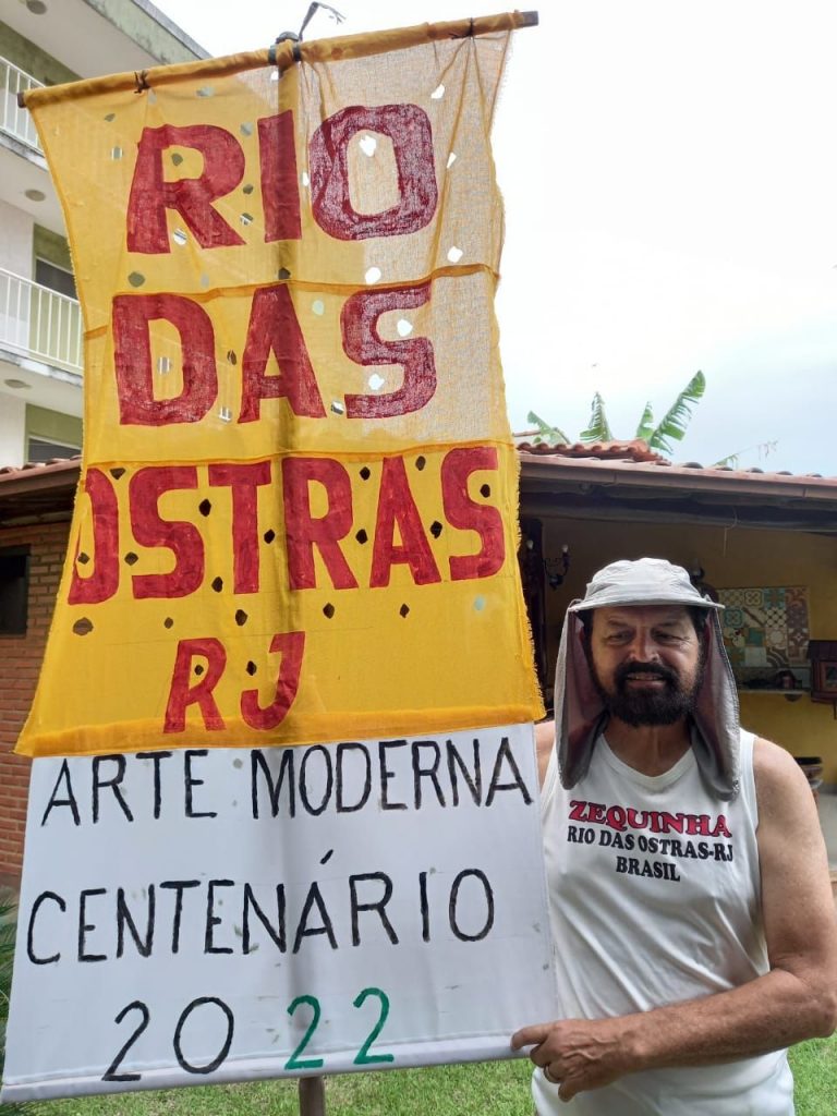 Corredor segura faixa onde se lê: Rio das Ostras - RJ - Arte Moderna - Centenário 2022