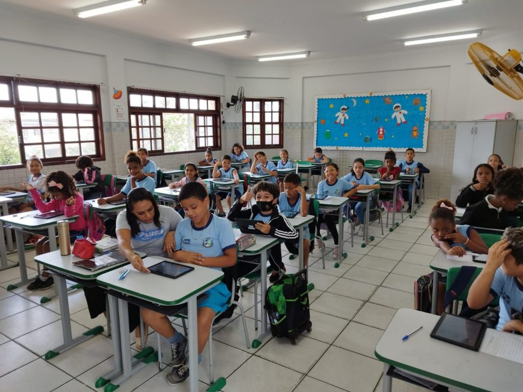 Alunos enfileirados nas carteiras em uma sala de aula