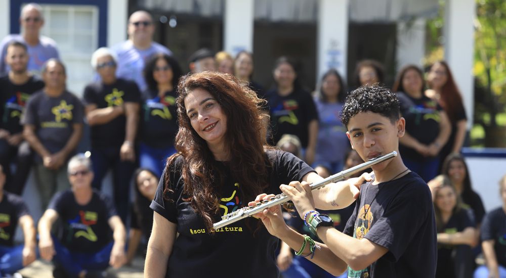 Presidente da Fundação de Cultura ao lado de jovem músico que toca flauta