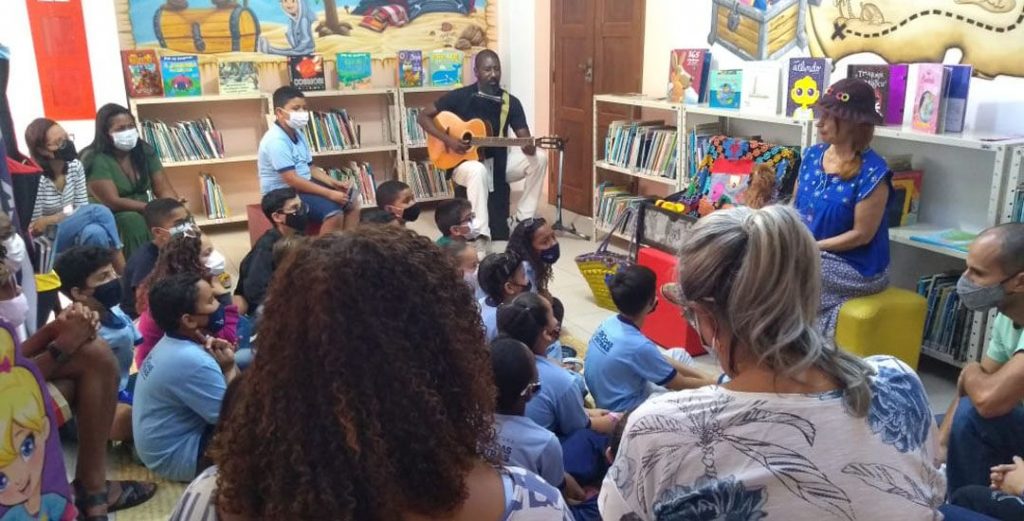 Contadores de história reunidos com alunos na biblioteca