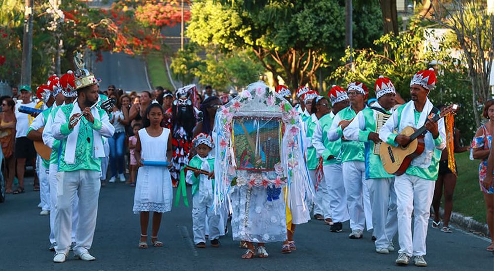 Grupo da folia de reis com roupas características, estandarte e instrumentos