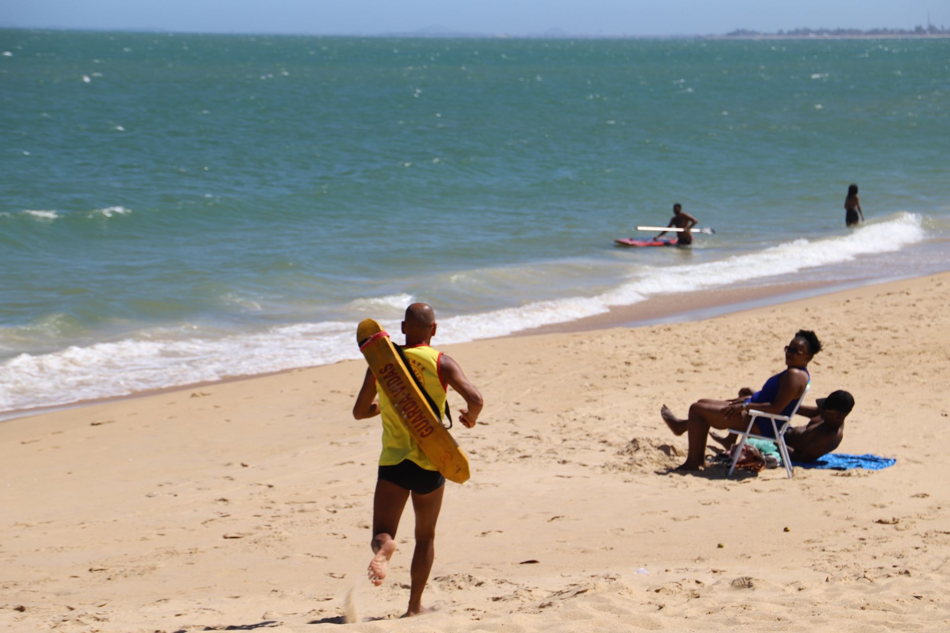 Guarda-vida correndo na areia da praia