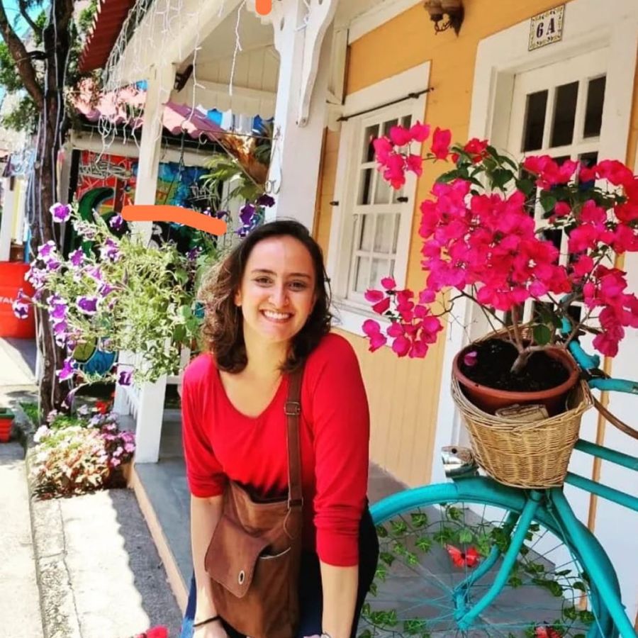 Foto posada da flautista sorrindo em cenário com flores