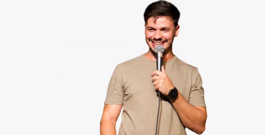 O ator Kwesny segura o microfone e sorri