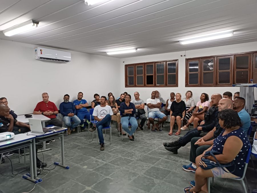 Grupo de moradores sentados participam da reunião com agentes de segurança