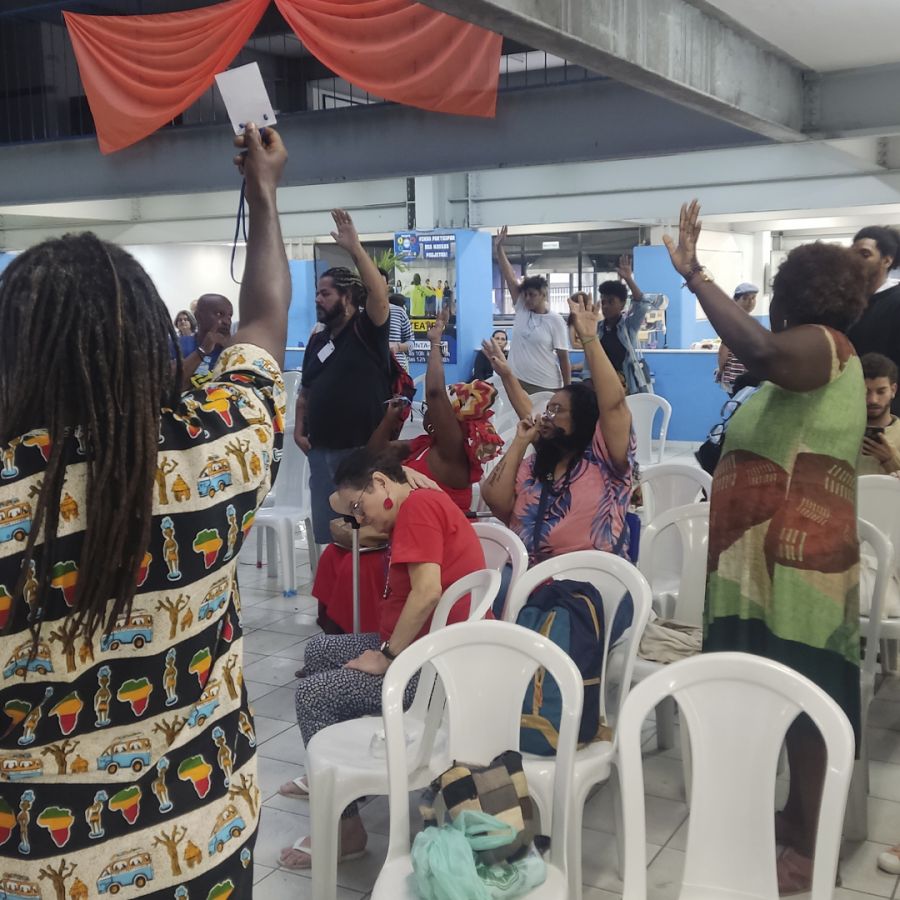 Participantes da conferência levantam os crachás para votar durante a Conferência Municipal de Cultura