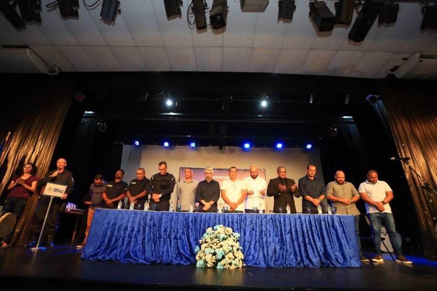 Mesa com autoridades colocada no palco do teatro