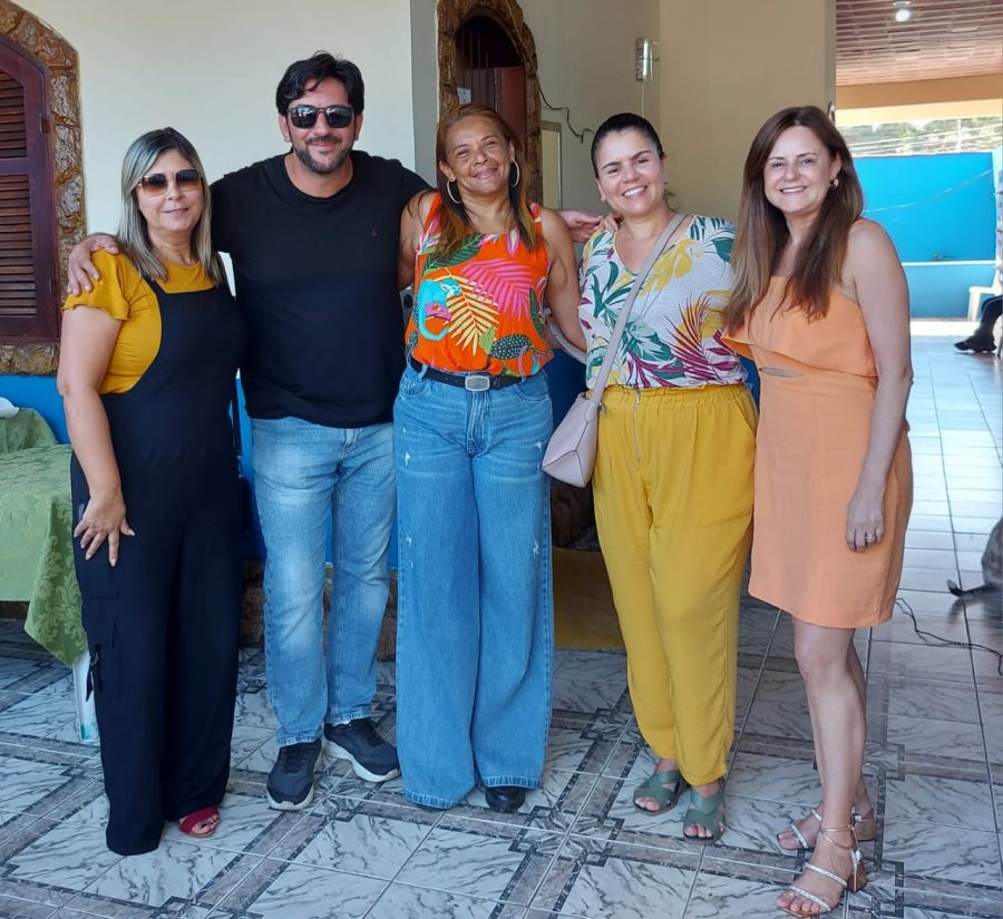 Autoridades de pé, abraçados na varanda da Casa do Sorriso.