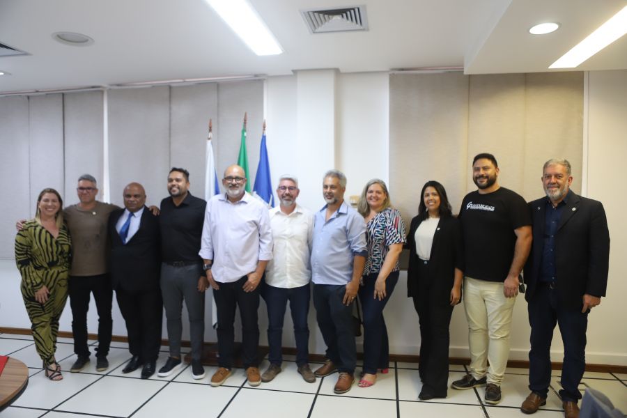 Autoridades perfiladas tendo ao fundo as bandeiras do município, estado do Rio de Janeiro e Brasil