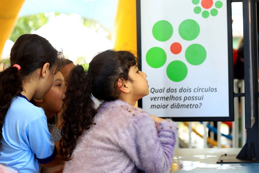 Meinina olhando tela com explicação sobre experimento