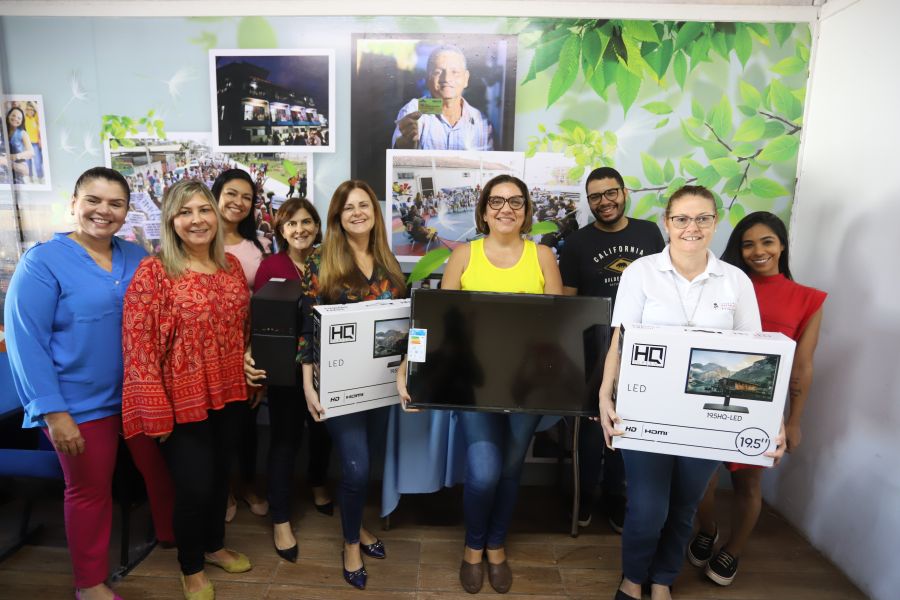 Servidores da secretaria de assistência social com a equipe da Pestalozzi e alguns deles estão com computadores e televisor .