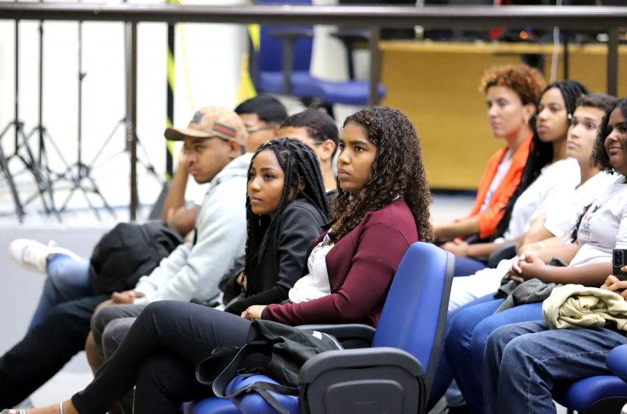 Jovens sentados na plenária da câmara de vereadores.