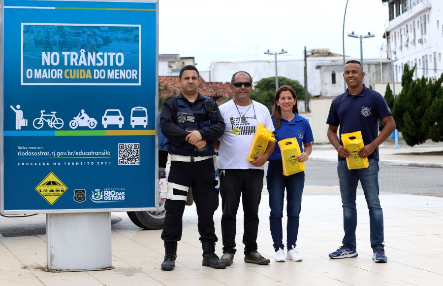 Servidores municipais ao lado de placa sobre Campanha de Trânsito