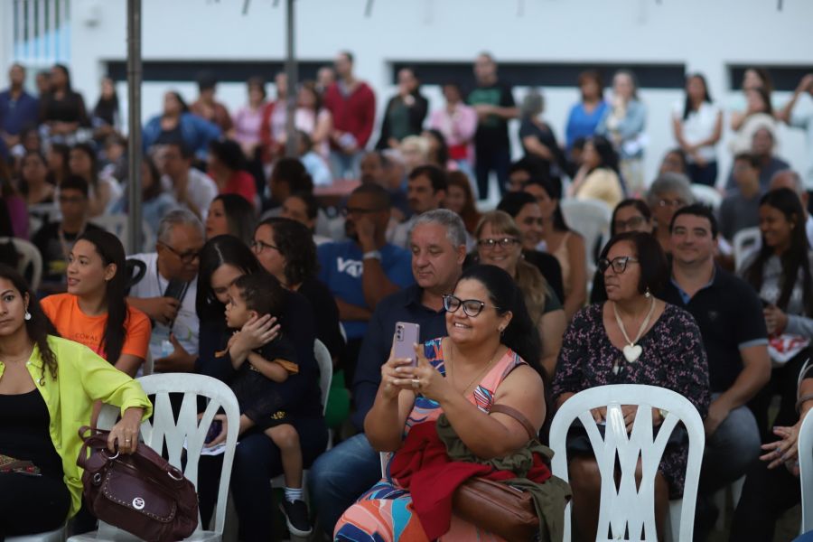 Plateia sentada, com algumas pessoas segurando celular