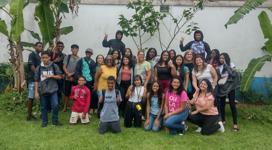 Alunos em pé, em grupo, em uma foto posada.