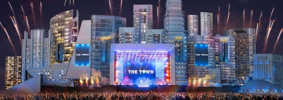 Palco de shows com telão ao fundo escrito The Town. Atrás deste palco prédios da cidade de São Paulo.