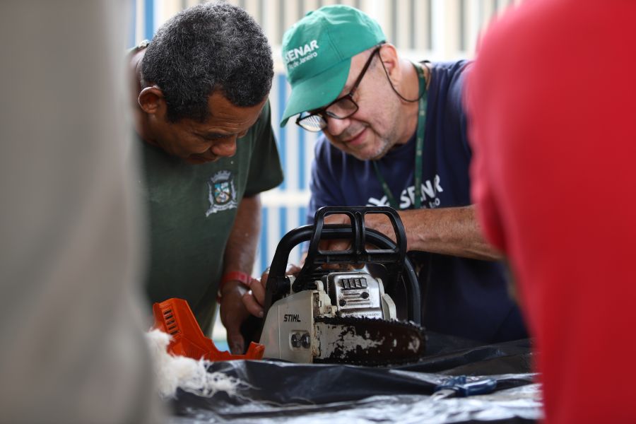 Instrutor em primeiro plano orientando sobre uso do maquinário
