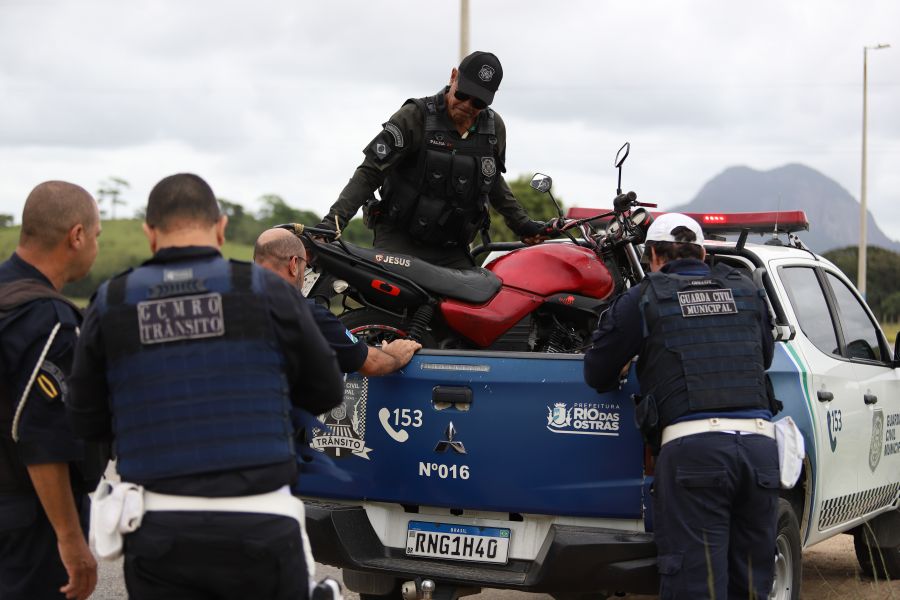 Moto sendo colocado pelos agentes na caçamba da viatura após verificação e constatação de veículo roubado