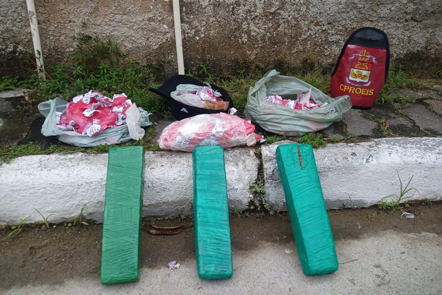 Tabletes e sacolas com drogas no chão de uma calçada