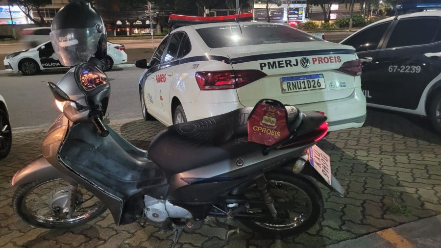 Moto cinza com a viatura parada que recuperou a moto