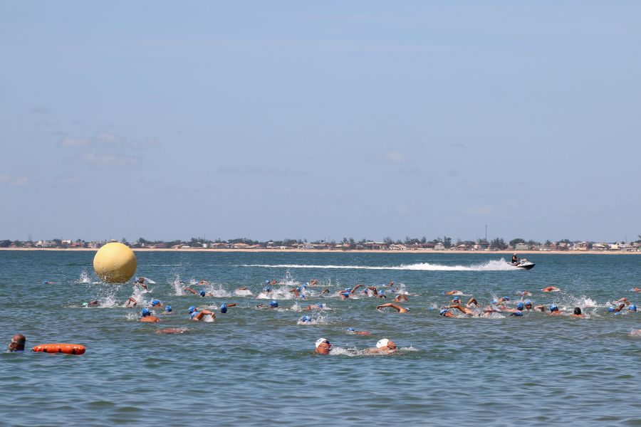 Na foto, dezenas de nadadores competem em alto mar.