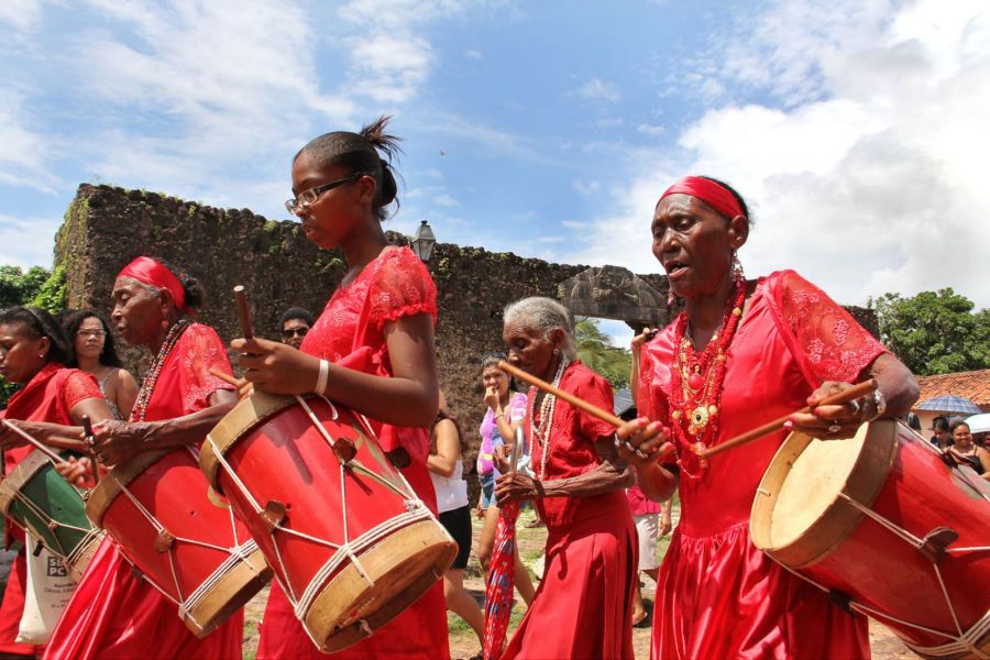 Mulheres vestidas de vermelho tocando tambores