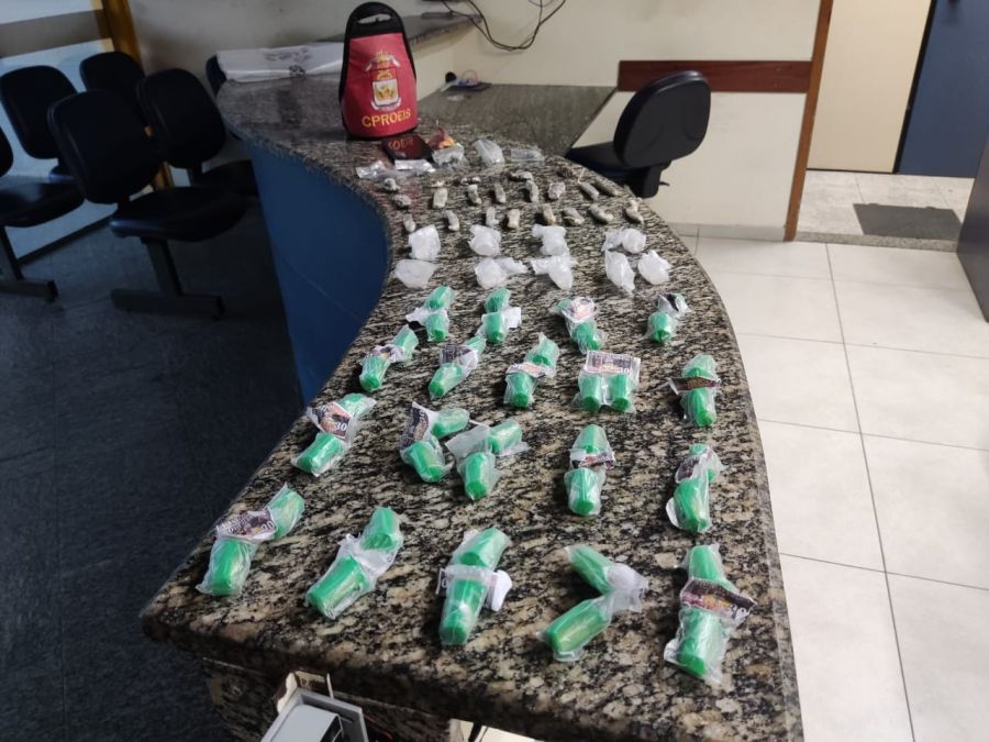 Drogas apreendias em cima do balcão e o braçal da guarnição