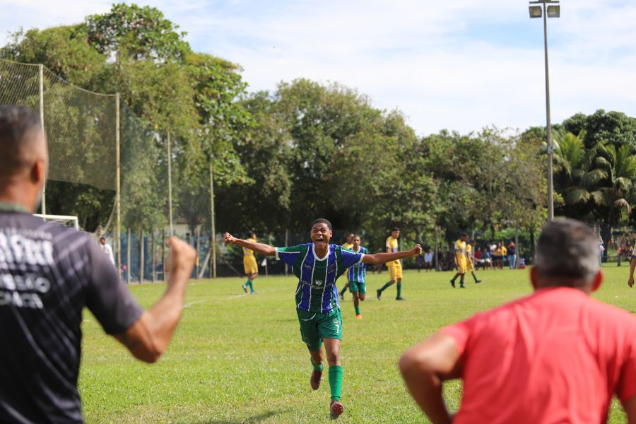 Um atleta com o uniforme do time de Rio das Ostras corre em direção ao treinador para comemorar o gol