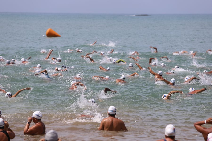 Na foto, dezenas de nadadores competem na praia do centro