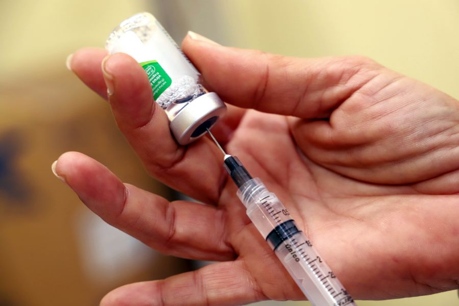 mão puxando líquido de imunizante na serings