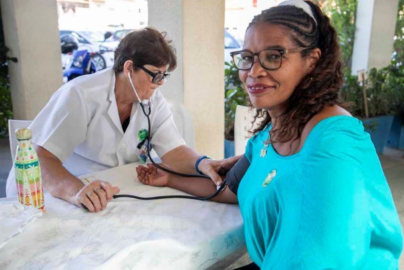 Profissional de saúde mede pressão arterial de uma mulher
